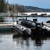 grey inflatable boat docked on a lake