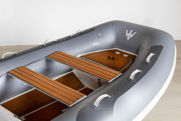 grey inflatable rigid hull inflatable boat with EVA foam on bench seats and floor. bow locker in front of boat also covered in Eva foam