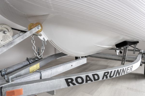 white rigid hull inflatable boat on road runner trailer