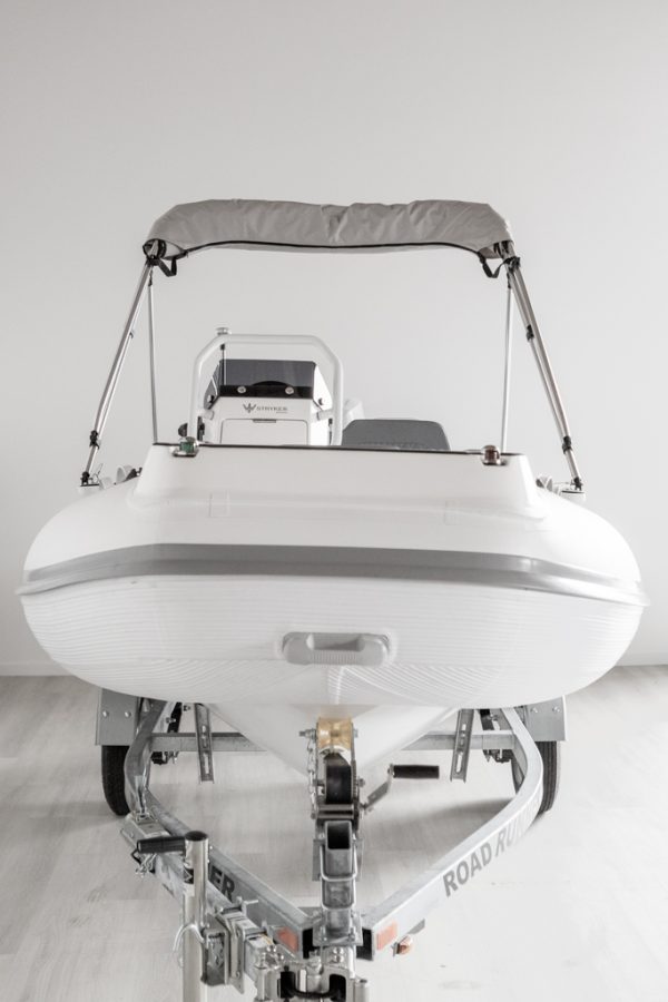 bow or front view of white rigid hull inflatable boat with bimini, integrated console and tohatsu outboard