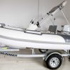 white rigid hull inflatable boat with bimini, integrated console and tohatsu outboard on road runner trailer