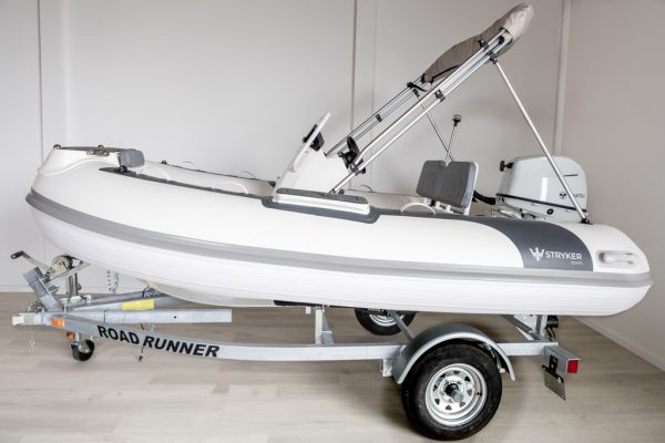 white rigid hull inflatable boat with bimini, integrated console and tohatsu outboard on road runner trailer