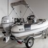 white rigid hull inflatable boat with bimini, integrated console and tohatsu outboard on road runner trailer