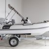 white rigid hull inflatable boat with bimini, integrated console and tohatsu outboard on road runner trailer