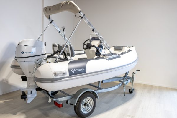 white rigid hull inflatable boat with bimini, integrated console and tohatsu outboard on road runner trailer