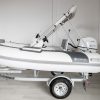 white rigid hull inflatable boat with bimini, integrated console and tohatsu outboard on road runner trailer