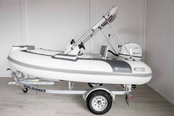 white rigid hull inflatable boat with bimini, integrated console and tohatsu outboard on road runner trailer