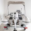 white rigid hull inflatable boat with bimini, integrated console and tohatsu outboard on road runner trailer